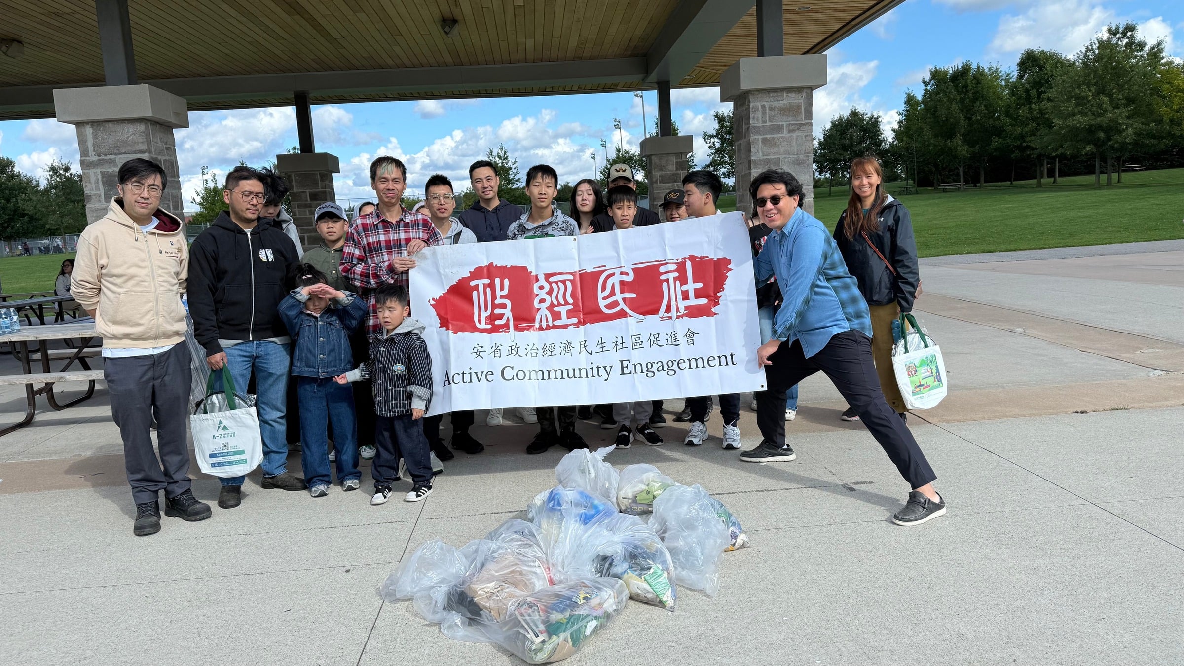 ACE Ontario volunteers with banner and litter bags under the pavilion at Berczy Park North