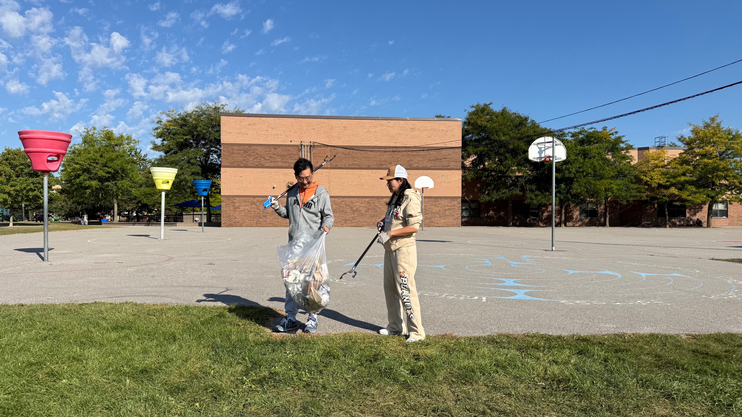 Volunteers cleaning a paved play area during the John Button Park cleanup