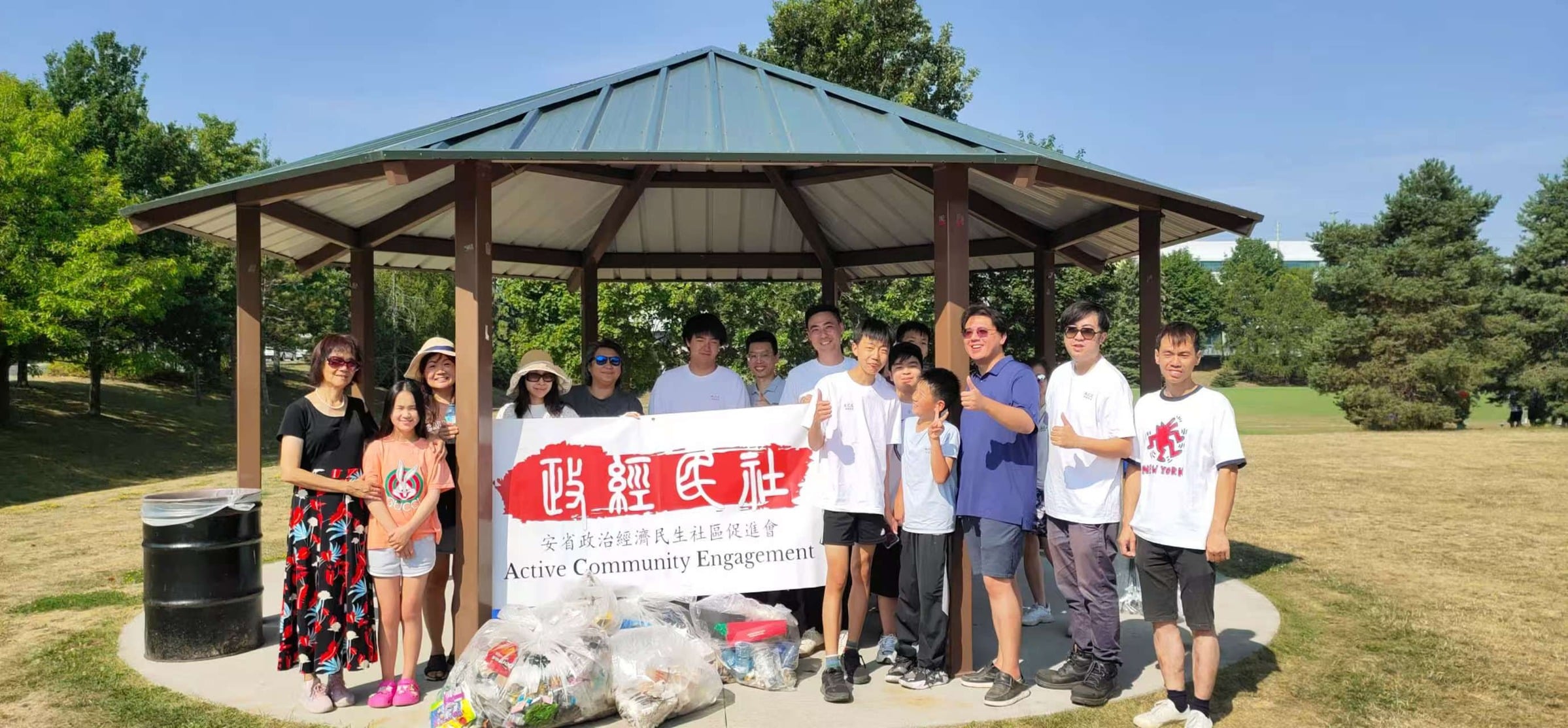 ACE Ontario volunteers with banner and litter bags under a park gazebo at Milliken Mills Park
